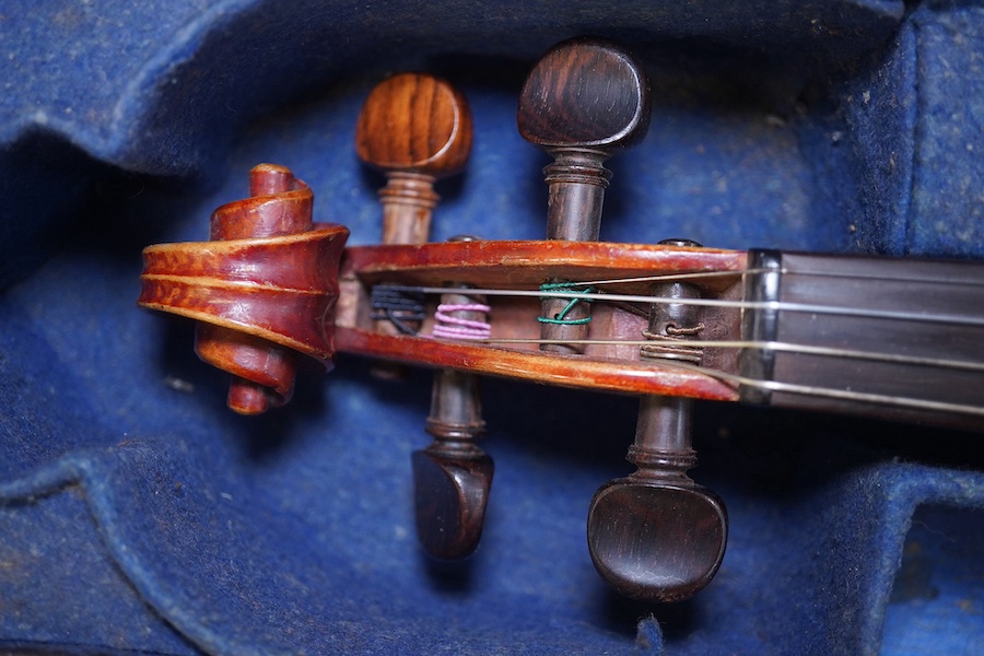 A late 19th century violin, bears fake Stradivarius label, cased, back measures 36cm. Condition - fair